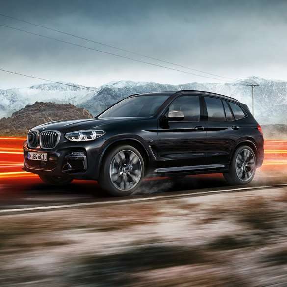 BMW X3 M40i et BMW X3 M40d, vue de profil. Extérieur des BMW X3 M40i et BMW X3 M40d en Saphierschwarz metallic, en mouvement, vue de profil devant un paysage montagneux avec bandes lumineuses.