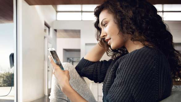 Une femme utilise l'App BMW Connected Une femme utilise les eDrive Remote Services avec l'App BMW Connected