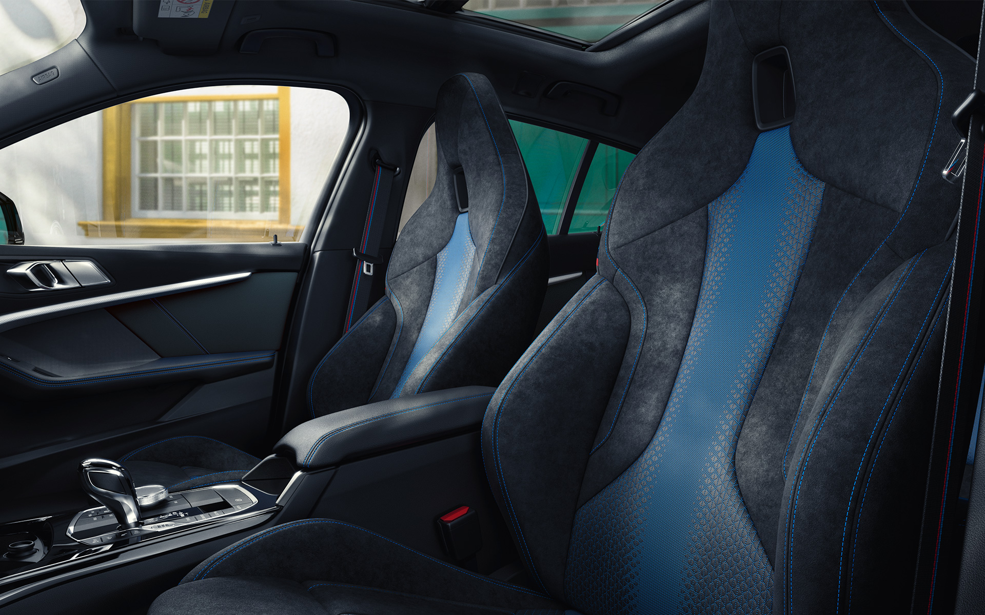 Sièges M sport de la BMW Série 1 F40 Sièges M sport au galbe ergonomique de la BMW Série 1 F40, avec surpiqûres contrastées bleues et appuie-têtes intégrés.