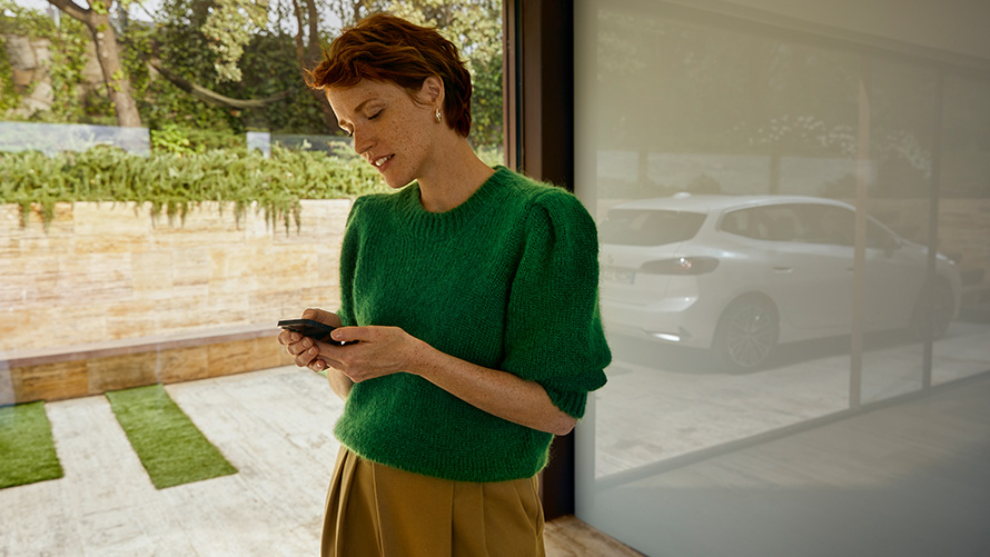 BMW Service Inclusive - femme avec un smartphone en main BMW Service Inclusive - femme avec un smartphone en main