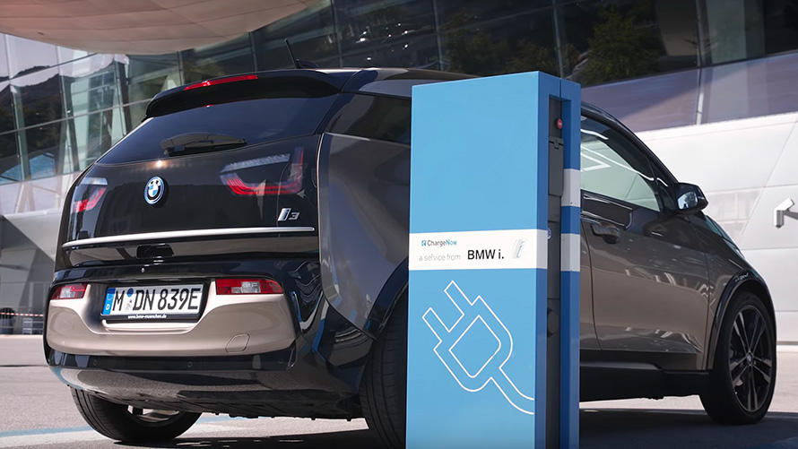 BMW Série 3 Berline G20 BMW i3 sur une borne de recharge vue de trois quarts arrière