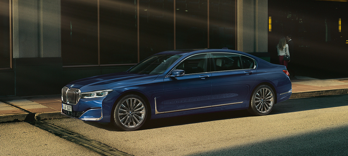 BMW Série 7 Berline Individual, vue latérale Vue latérale d’une BMW Série 7 Berline Individual rouge dans un décor urbain