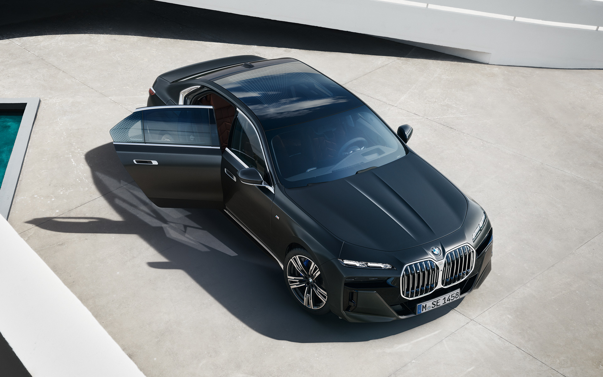 Vue en plongée BMW Série 7 Berline G70 ICE 740d kit M Sport Frozen Deep Grey metallic BMW Série 7 Berline G70 ICE 740d kit M Sport Frozen Deep Grey metallic vue en plongée avec portière arrière ouverte