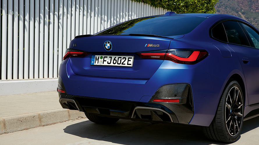 BMW i4 M50 G26 2021 BMW Individual Frozen Portimao Blau metallic vue de trois quarts arrière à l’arrêt près d’une clotûre blanche
