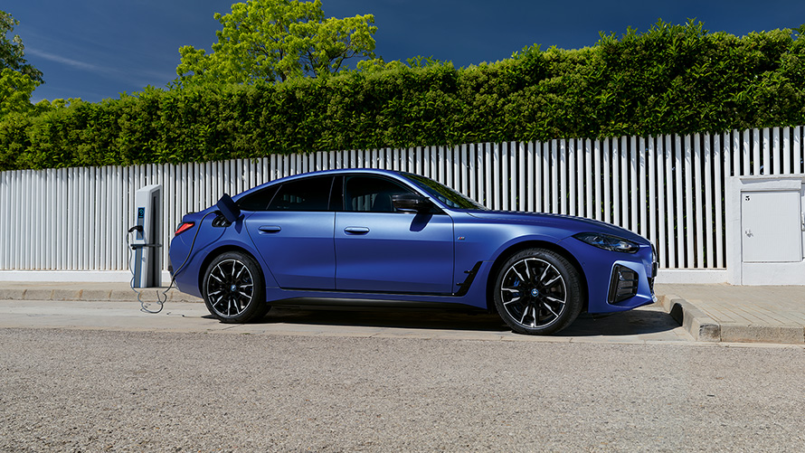 BMW i4 M50 G26 2021 BMW Individual Frozen Portimao Blau metallic branchée à une borne de recharge vue de profil