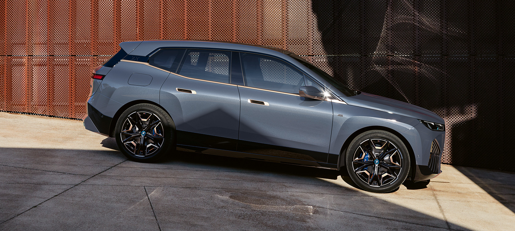 BMW iX M60 i20 2022 SUV électrique BMW Individual Storm Bay metallic vue de profil en stationnement BMW iX M60 i20 2022 SUV électrique BMW Individual Storm Bay metallic vue de profil en stationnement