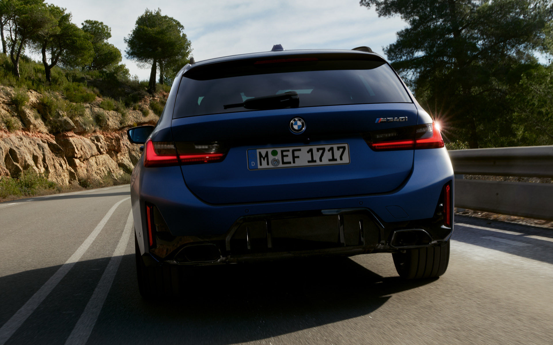 BMW M340i xDrive Touring G21, vue arrière en mouvement sur la route BMW M340i xDrive Touring G21 Frozen Tanzanite Blue vue arrière en mouvement sur la route