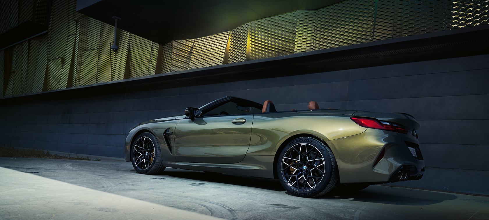 La nouvelle BMW M8 Competition Cabrio F91 LCI restylage 2022 BMW Individual Brass metallic, vue de trois quarts de profil devant un mur