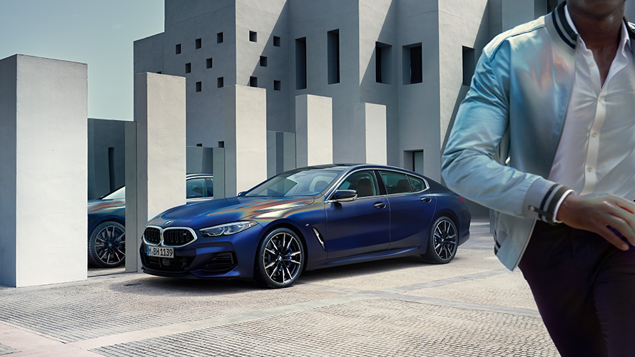 BMW M850i xDrive Gran Coupé G16 LCI restylage 2022 BMW Individual Frozen Tansanitblau metallic vue de trois quarts avant à l’arrêt avec modèle masculin au premier plan