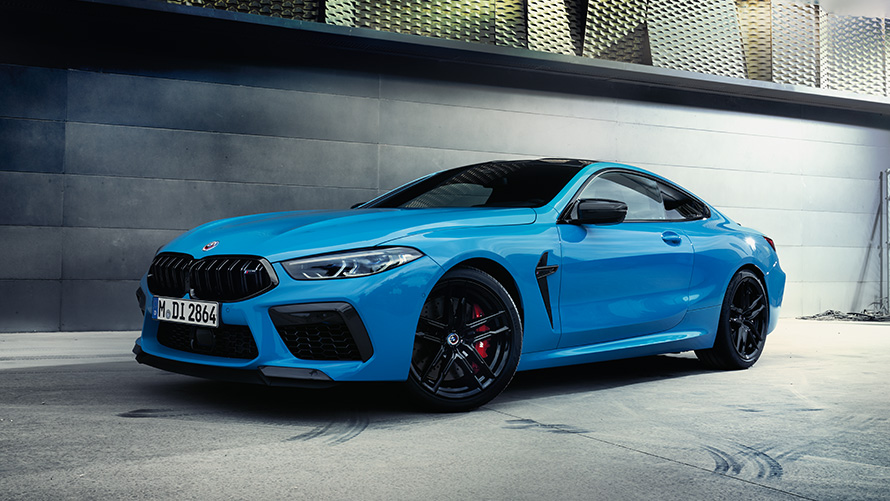 BMW M8 F92, vue de trois quarts arrière en stationnement avec mannequin Modèles BMW M BMW M8 F92, vue de trois quarts arrière en stationnement avec mannequin