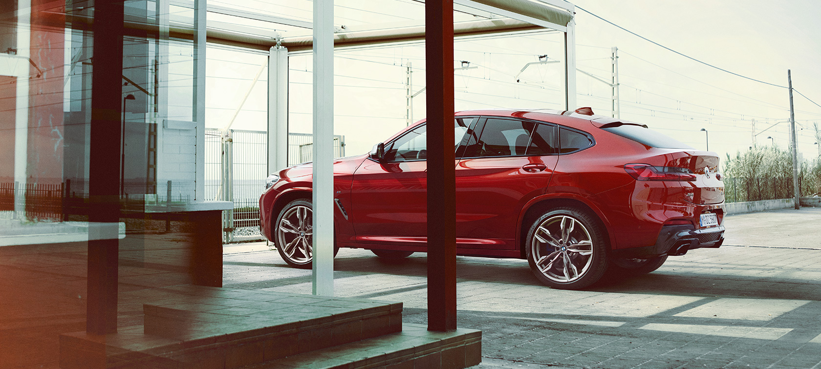Vue de profil de la BMW X4 BMW X4 M40i G02 2018 en Flamencorot Brillanteffekt, vue de profil en stationnement