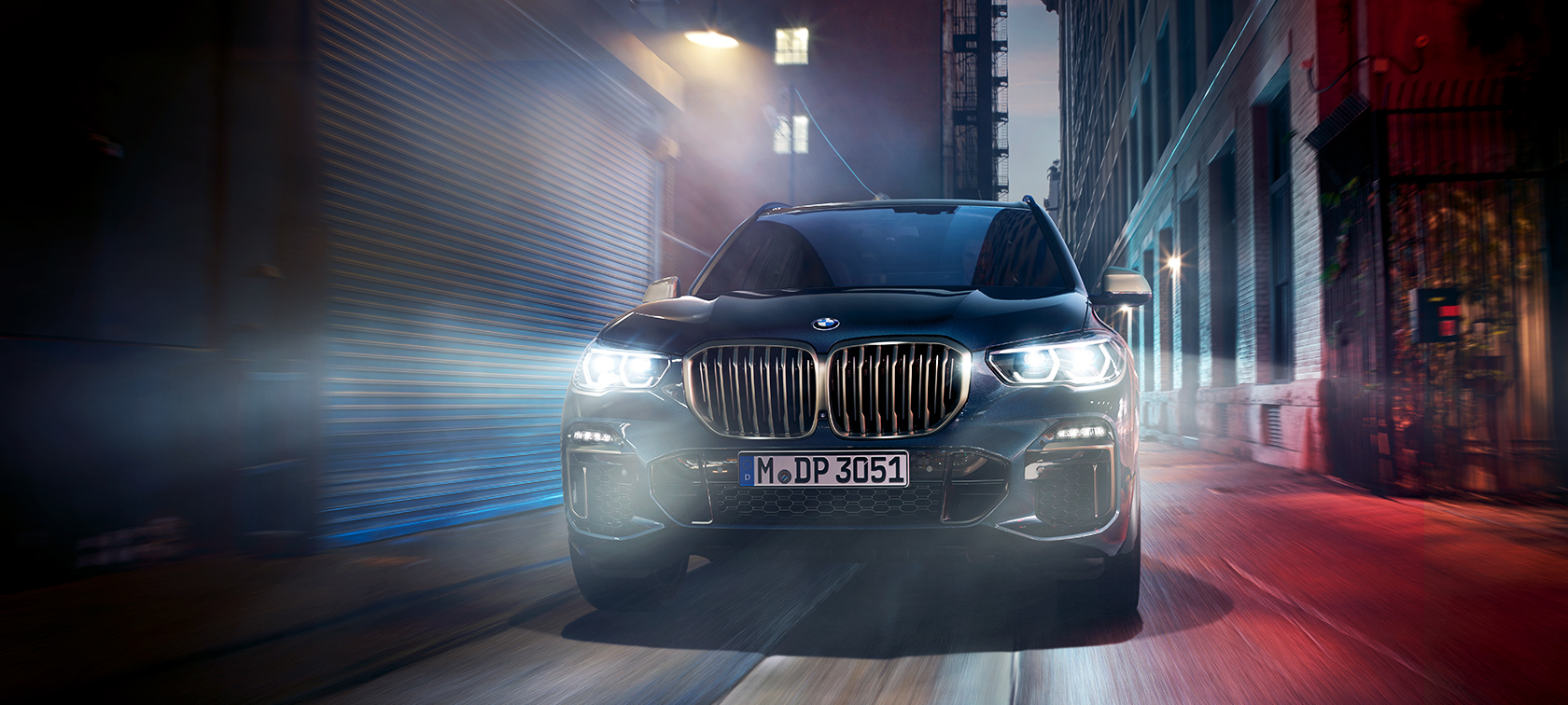 La BMW X5 M50d en action La BMW X5 M50d la nuit, dans une rue en ville.
