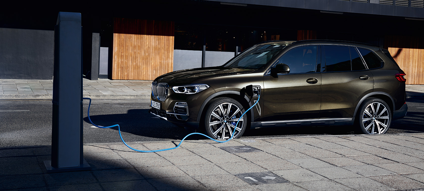Plug-in Hybrid BMW X5 xDrive45e G05 vue de trois quarts de profil Plug-in Hybrid BMW X5 xDrive45e G05 vue de trois quarts de profil en charge