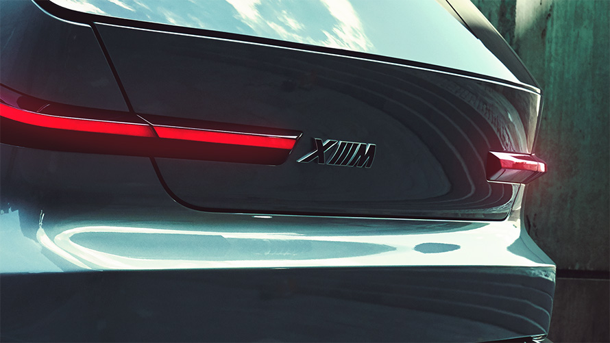 BMW Concept XM (G09) vue de trois quarts arrière à l’arrêt avec gros plan sur le logo XM