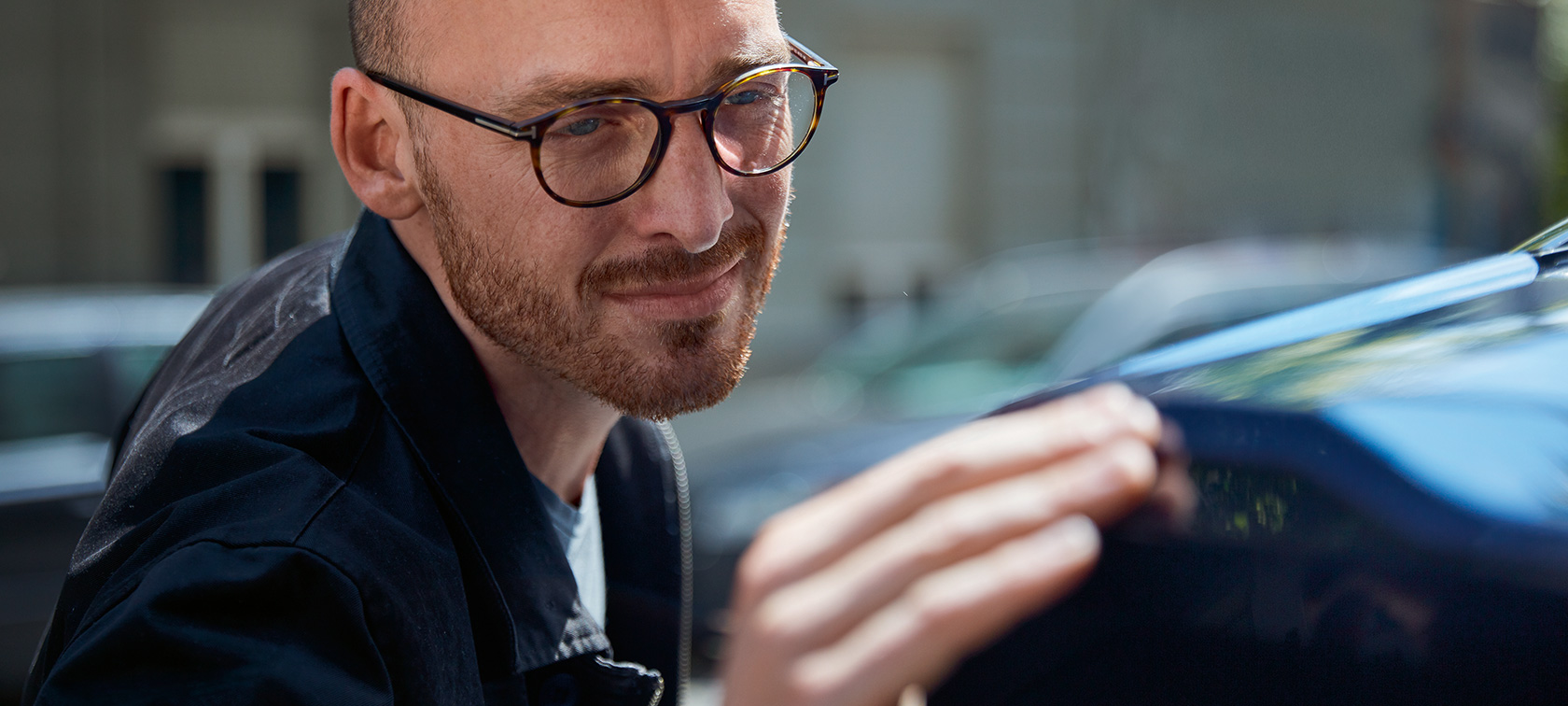 Un homme bichonne sa BMW.